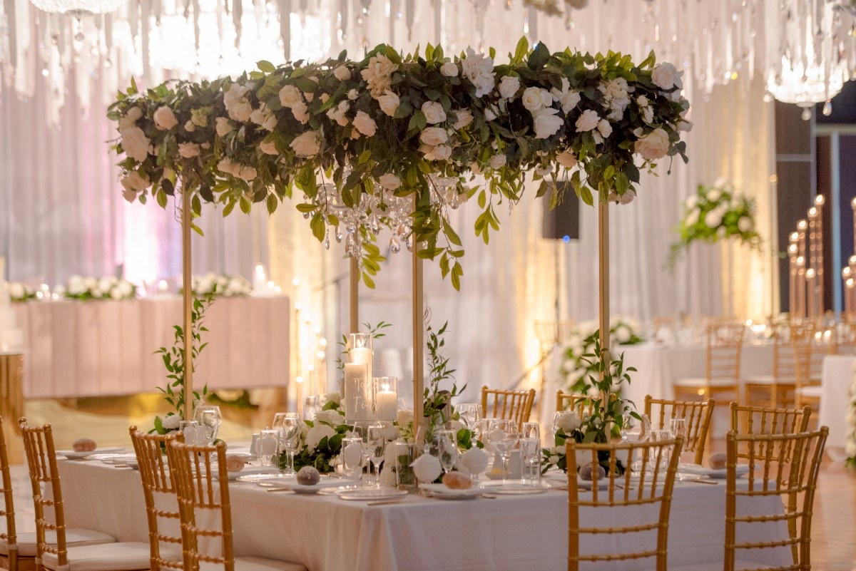 Round wedding table with white flowers and gold chairs in Heritage Hall