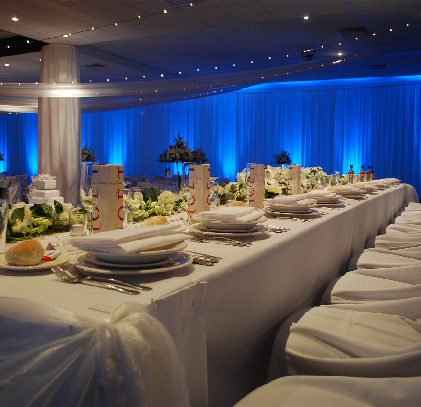 Long dining table in The Gallery under blue event lighting